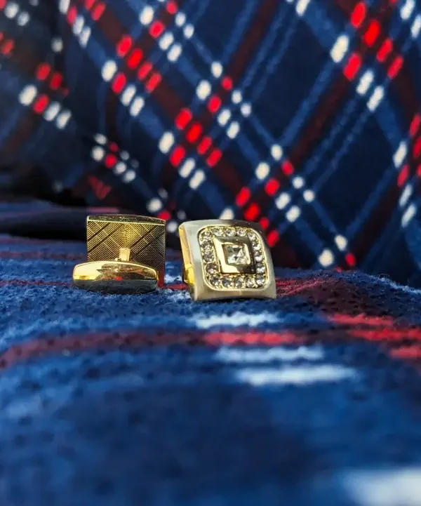 gold cufflinks for men on the blue cloth background