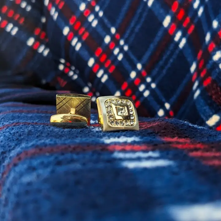 gold cufflinks for men on the blue cloth background