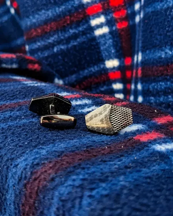 Black Cufflinks on the rough blue clothe