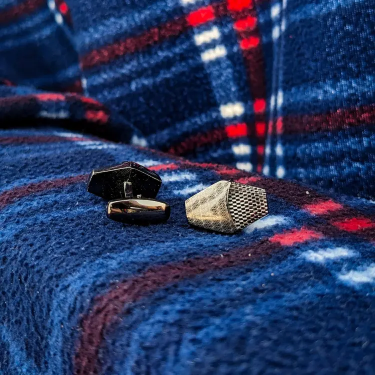 Black Cufflinks on the rough blue clothe